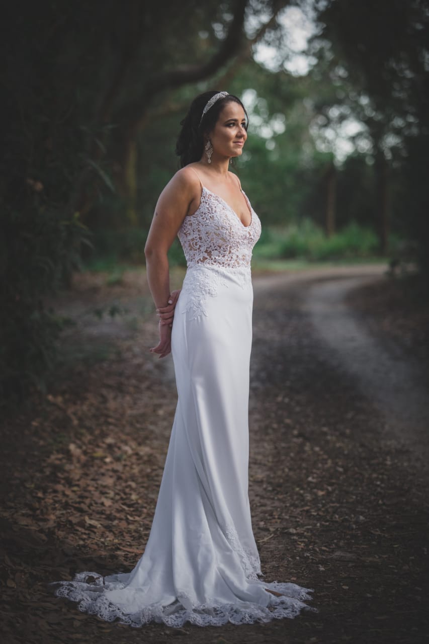 samantha Crepe & Lace Sheath Bridal Gown with Long Lace Train  The Samantha gown is an effortlessly elegant choice for the bride who loves clean lines with soft, romantic detail. Crafted from luxurious crepe and delicate lace, this gown is designed to create a timeless silhouette with modern refinement.  ✨ Design Highlights: ✔ V-Neckline Bodice – Flattering and feminine with a sheer lace overlay. ✔ Thin Straps – Delicate and minimal, perfect for a light and airy bridal look. ✔ Sheer Lace Bodice – Adds intricate texture and soft sensuality. ✔ Low Open Back – Finished with a row of buttons for a touch of classic bridal charm. ✔ Fitted Sheath Silhouette – Smooth and body-skimming for a sleek, contemporary shape. ✔ Long, Lace-Edged Train – Romantic and dramatic, ideal for a grand aisle entrance.  💫 Customization Options: ✅ Available in standard sizes or tailored to your exact measurements ✅ Option to adjust neckline, strap style, or train length ✅ Can be made in off-white or white crepe and lace ✅ Add a detachable overskirt or sleeves upon request  👑 A gown for the bride who desires understated luxury with a romantic edge. Perfect for a chic, graceful walk down the aisle. 👑  📞 Book your bridal fitting today! 📧 info@bestersbridal.co.za | 📱 084 268 1354