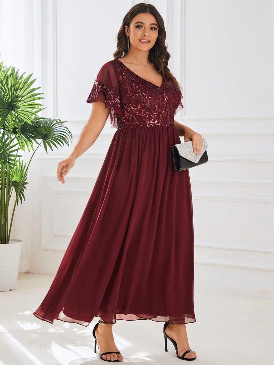 Hazel A sophisticated Mother of the Bride dress featuring a sparkling sequin V-neck bodice, soft short sleeves, and a smooth, flowing skirt for timeless elegance.  This dress is not currently in stock but is available to order.