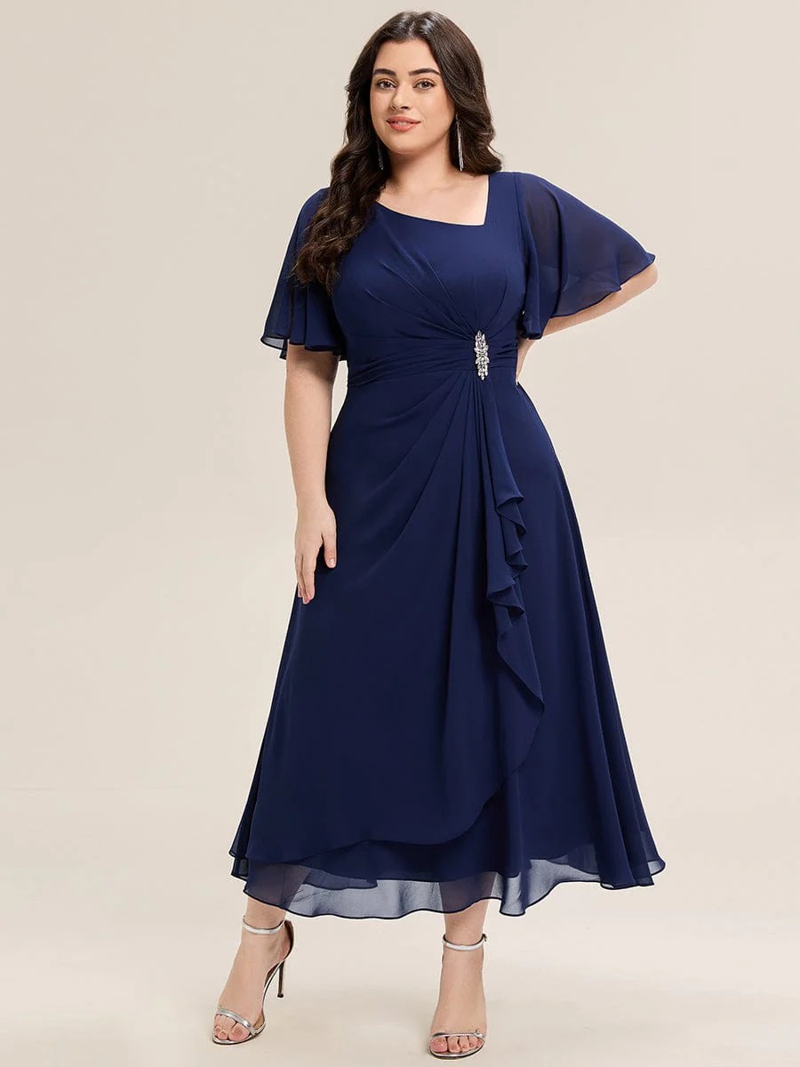 Lilou A beautifully pleated chiffon midi dress designed for plus-size elegance, featuring soft ruffle sleeves and a flattering flowy silhouette — perfect for any special celebration.  This dress is not currently in stock but is available to order.