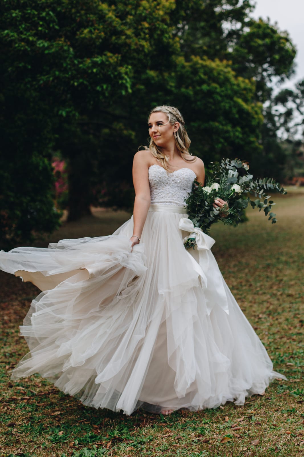 MESCHE This enchanting blush ball gown combines delicate lace and soft tulle, creating a dreamy, romantic bridal look. The bodice features a sweetheart neckline adorned with intricate beaded lace, adding a touch of sparkle and luxury. A satin belt cinches the waist, offering a flattering silhouette and adding a hint of elegance. The back of the gown is fitted with a discreet zipper closure, ensuring a seamless finish. The full-flare skirt is crafted from layers of tiered tulle, cascading gracefully for a voluminous, fairy-tale effect. This gown is perfect for a bride looking for a regal and ethereal statement piece on her special day.