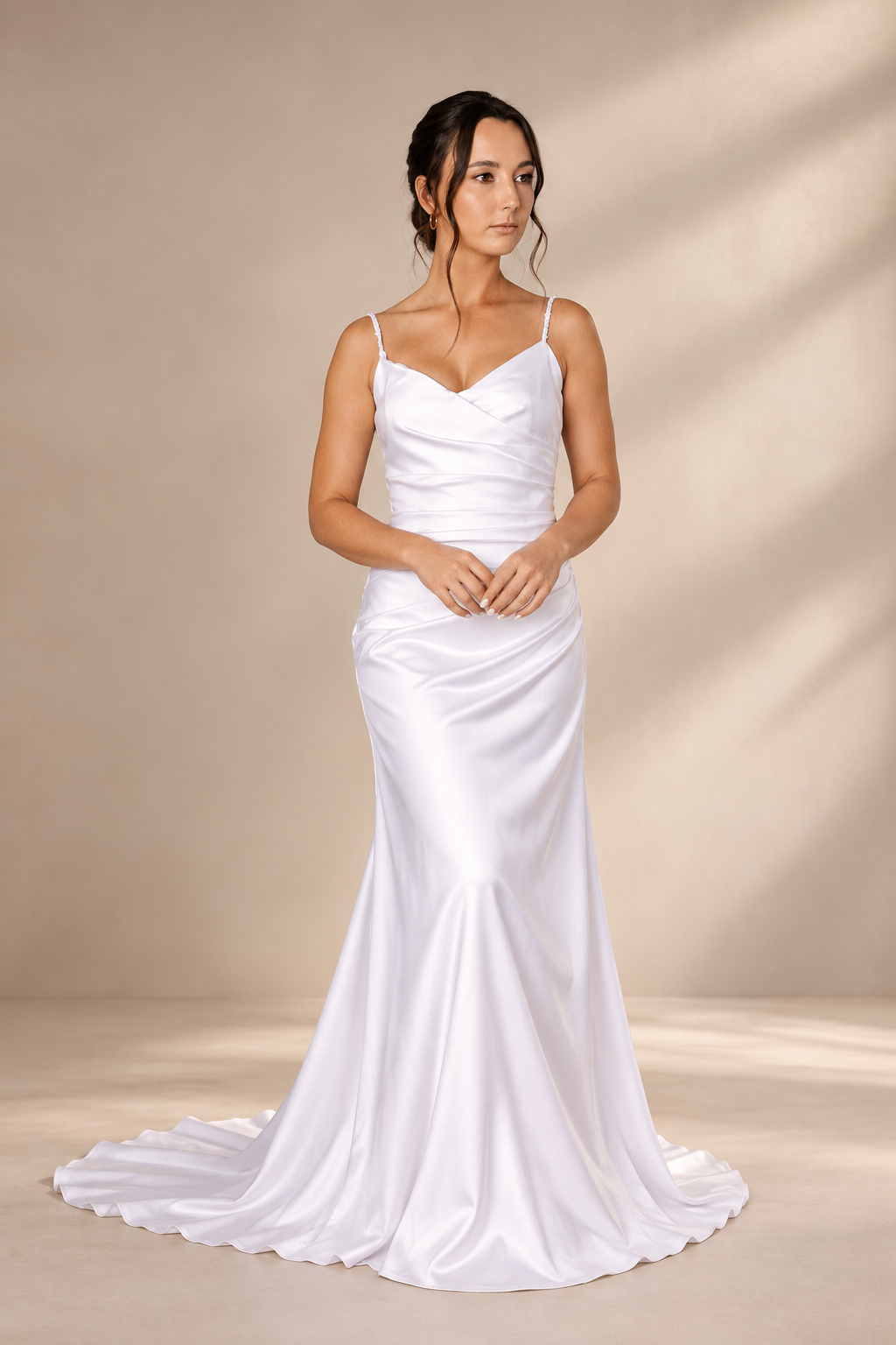 JOLENE A timeless mermaid wedding dress featuring a beautifully detailed lace bodice with a deep illusion V-neckline and delicate beaded straps. The sleek fitted silhouette flows effortlessly into a soft flared skirt and graceful lace-edged train