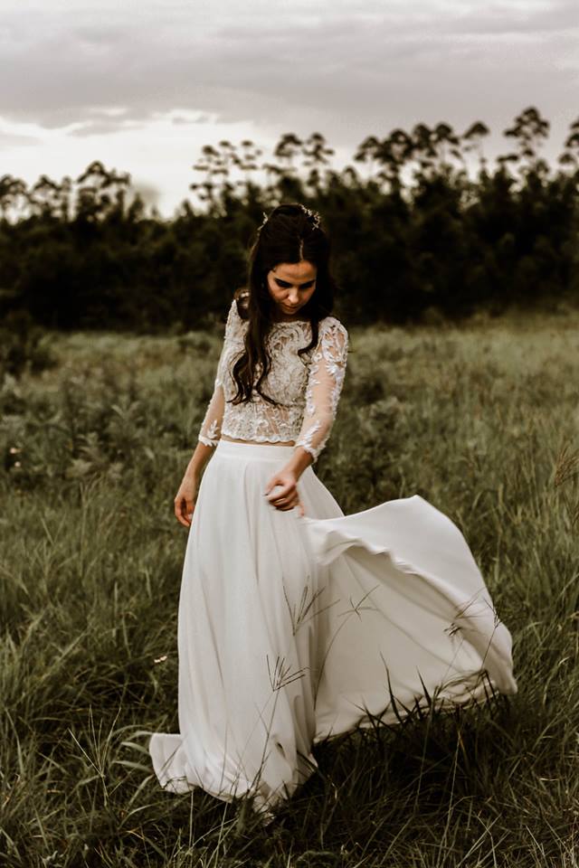 DRESS RUTHA boho-inspired two-piece wedding dress featuring a beautifully embroidered and beaded sheer lace crop top with delicate 3/4 sleeves. Paired with a flowing A-line chiffon skirt that drapes effortlessly, the ensemble is finished with a short, graceful train for a touch of elegance. The top is designed with a button closure, adding a classic detail to this modern, free-spirited bridal look—perfect for the bride who desires both comfort and a chic, romantic vibe. The dress is available for custom orders, tailored to your exact measurements in the colour of your choice. You can personalize it further by selecting either a long or short train, with short or long sleeves, and with or without a slit.