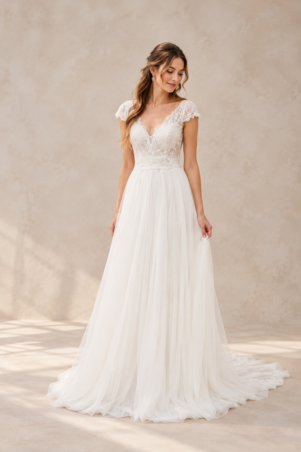 JOLENE A timeless mermaid wedding dress featuring a beautifully detailed lace bodice with a deep illusion V-neckline and delicate beaded straps. The sleek fitted silhouette flows effortlessly into a soft flared skirt and graceful lace-edged train