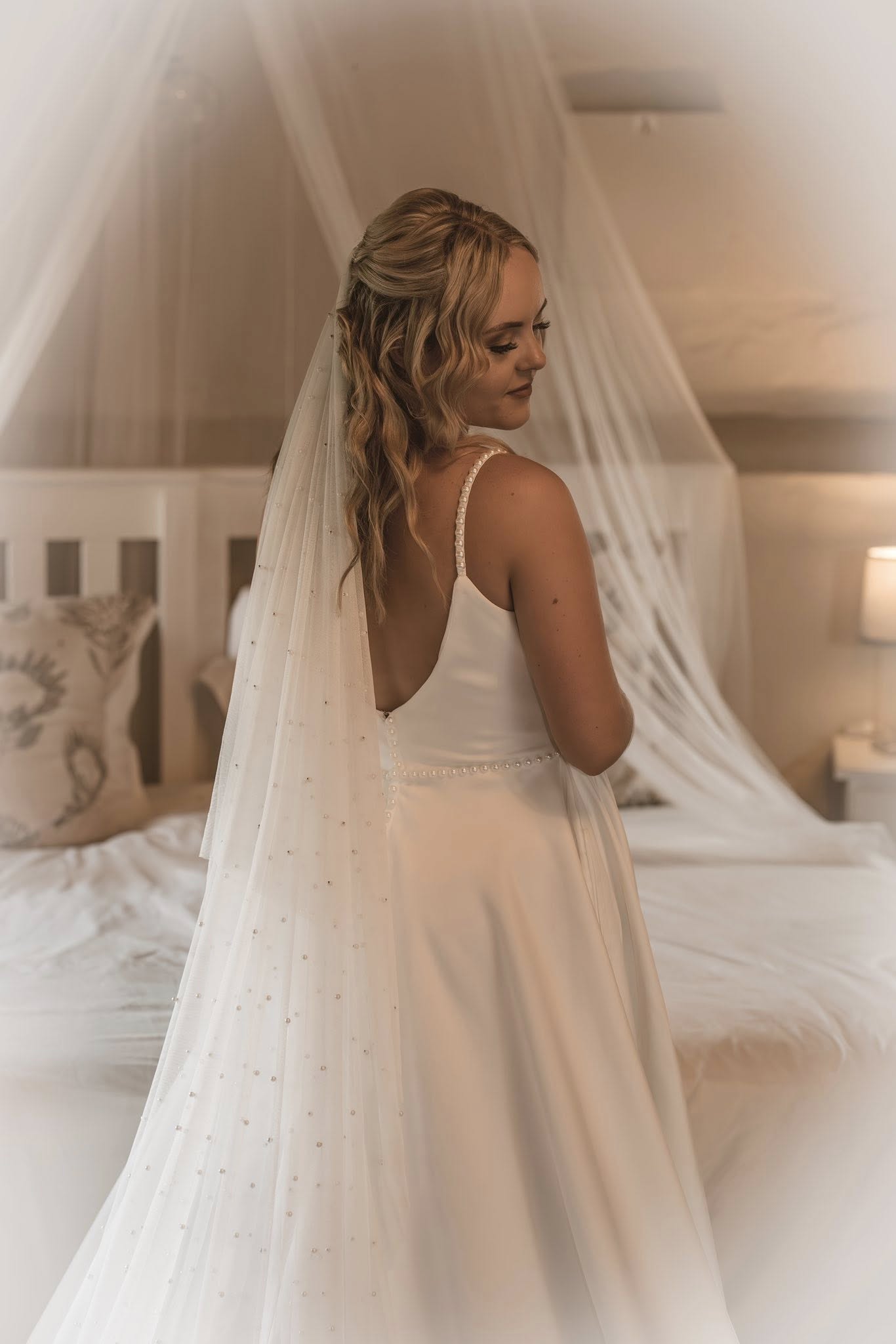 amanda Amanda – Timeless A-Line Bridal Gown with Pearl Elegance  For the bride who adores modern simplicity with luxurious detail, the Amanda gown offers a stunning fusion of elegance and grace, crafted in rich winter white Milano stretch for structure, comfort, and refined sophistication.  ✨ Design Highlights: ✔ Pearl Straps – Delicate and romantic, adding subtle sparkle and charm. ✔ V-Neckline Bodice – Flattering and timeless, paired with a beautifully contoured fit. ✔ Low V-Back with Pearl Button Closure – A classic detail with modern allure. ✔ Full-Flare A-Line Skirt – Flows effortlessly with side pockets for a modern touch. ✔ Long Train – Adds soft drama and a regal finish as you walk down the aisle. ✔ Pearl Waist Belt – Accentuates the waist with elegance and definition.  💫 Customization Options: ✅ Expert alterations for a flawless, made-for-you fit ✅ Detachable train or modified length available on request ✅ Add custom embellishments or neckline adjustments ✅ Optional pearl sleeve or strap variation  👑 Amanda is the gown for the bride who dreams of understated luxury with polished pearl detail. A perfect balance of minimalism and glamour. 👑  📞 Custom fitting & appointments welcome! 📧 info@bestersbridal.co.za | 📱 084 268 1354