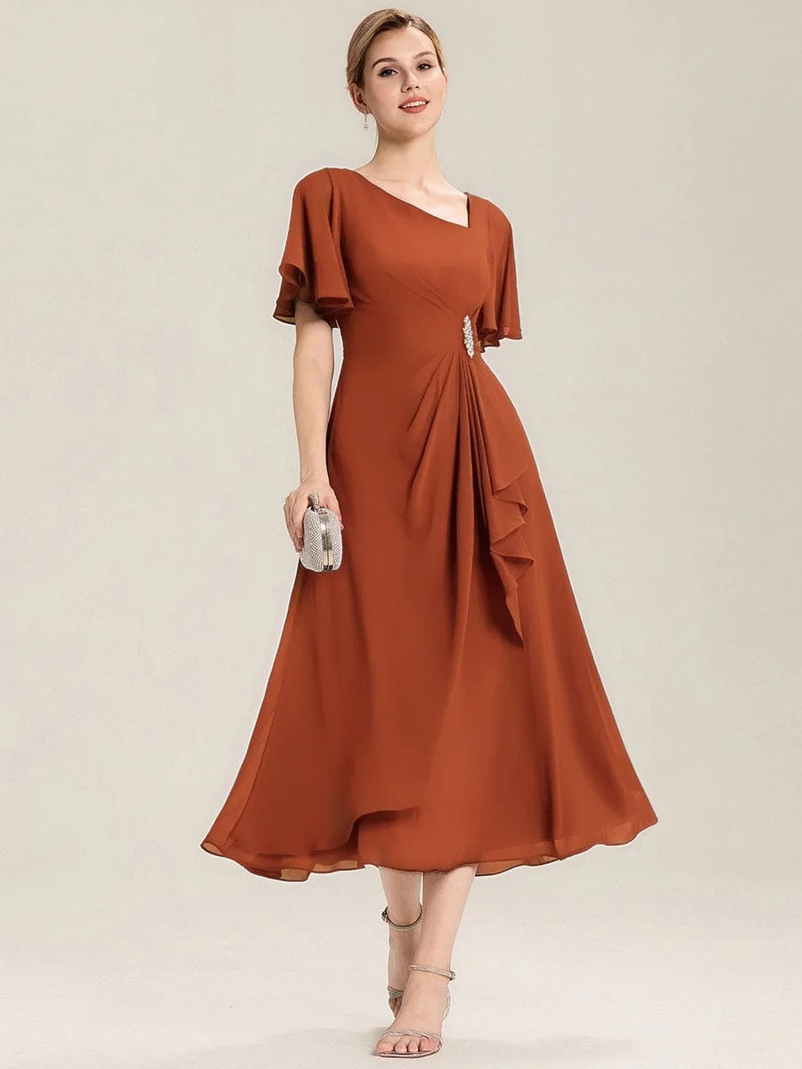 Lilou A beautifully pleated chiffon midi dress designed for plus-size elegance, featuring soft ruffle sleeves and a flattering flowy silhouette — perfect for any special celebration.  This dress is not currently in stock but is available to order.