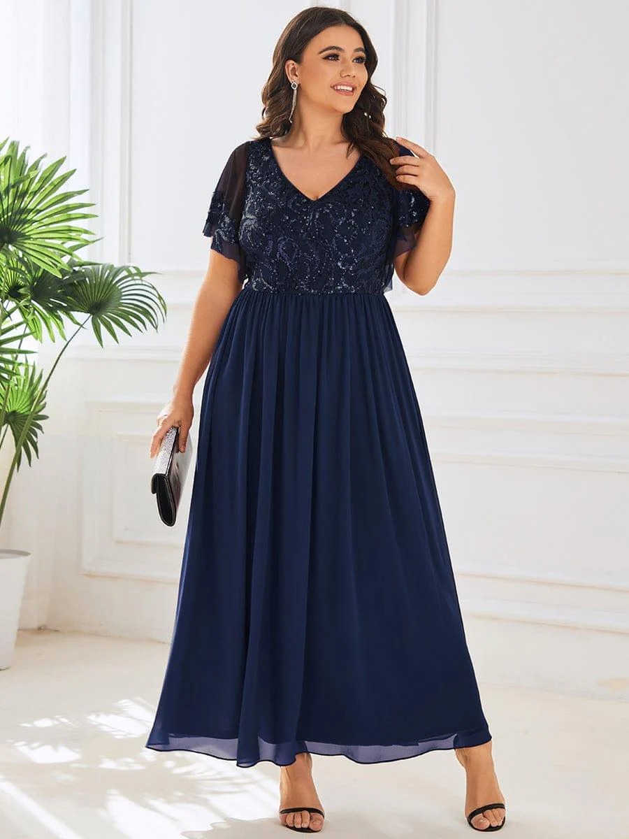 Hazel A sophisticated Mother of the Bride dress featuring a sparkling sequin V-neck bodice, soft short sleeves, and a smooth, flowing skirt for timeless elegance.  This dress is not currently in stock but is available to order.