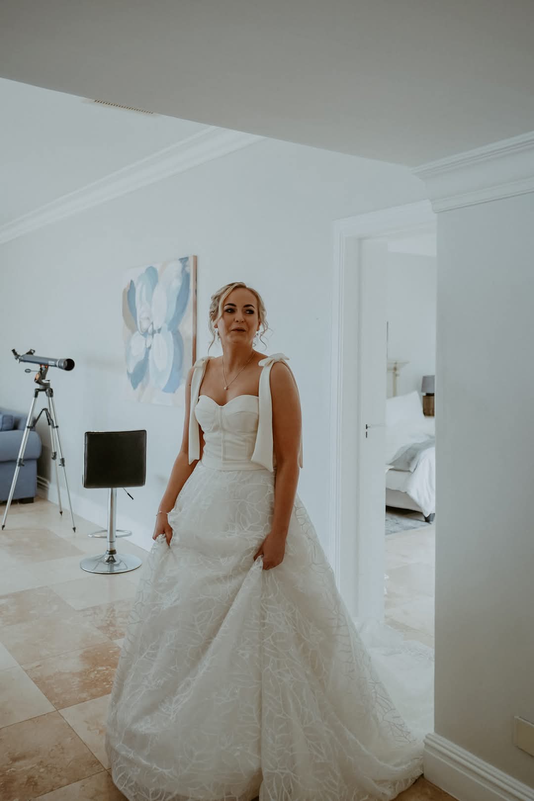 Key Features: Fabric: A refined combination of crepe, satin, and lace, offering a perfect blend of structure, elegance, and fluidity.  Colour: Ivory, for a soft, radiant, and timeless bridal look.  Available Sizes: 8–12, with expert final fitting alterations for a flawless custom fit.  Included Accessories: A long, two-tier bridal veil and a bridal garter, completing the ensemble with a touch of classic sophistication.  This gown is ideal for the modern bride who seeks effortless elegance, romantic detailing, and graceful movement, ensuring an unforgettable walk down the aisle.