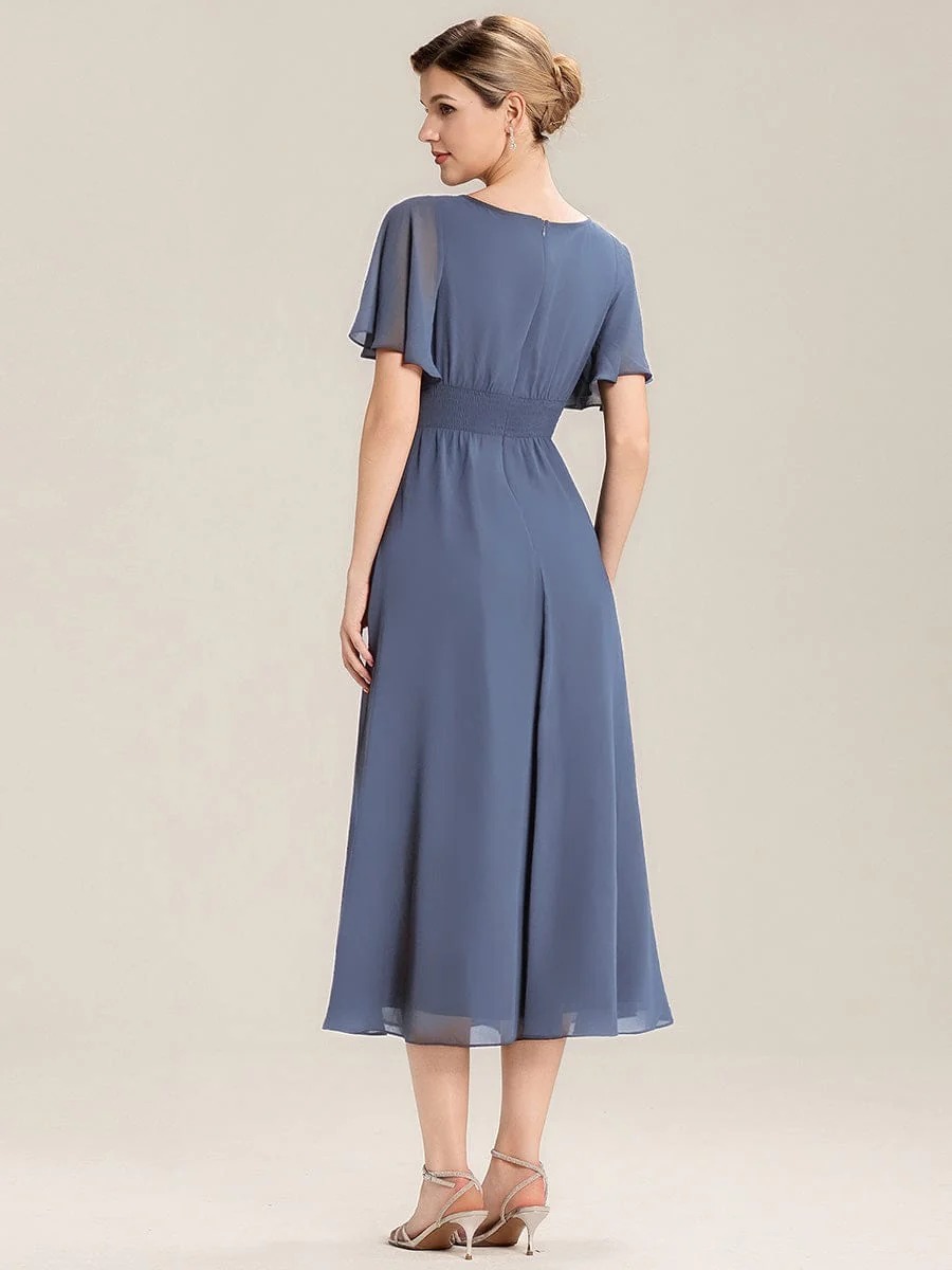 Lilou A beautifully pleated chiffon midi dress designed for plus-size elegance, featuring soft ruffle sleeves and a flattering flowy silhouette — perfect for any special celebration.  This dress is not currently in stock but is available to order.